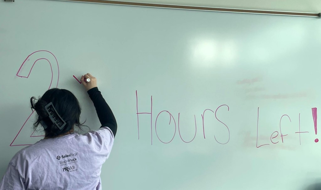 Person changing text on a whiteboard.